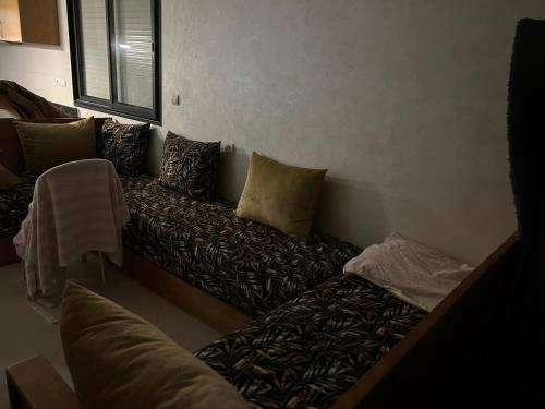 un sofá con almohadas en la sala de estar en Centre d estivage, en Moulay Bousselham