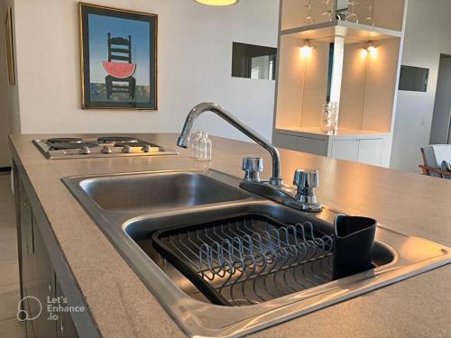 a kitchen sink with a dish drying rack in it at Increíble departamento en malecón frente al mar in Mazatlán