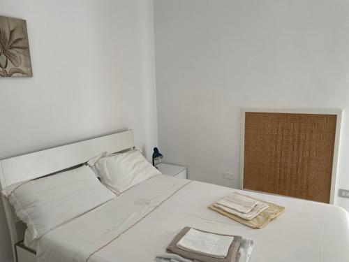 - un lit blanc avec 2 serviettes dans l'établissement Apulia Rosè, à Lecce