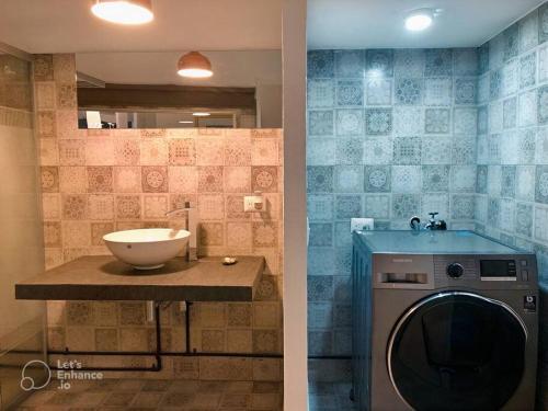 a bathroom with a washing machine and a sink at Increíble departamento en malecón frente al mar in Mazatlán