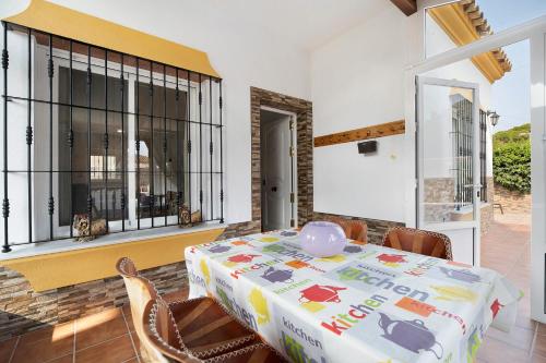 una sala da pranzo con tavolo, sedie e una finestra di Andalucia 13 Chiclana a Chiclana de la Frontera