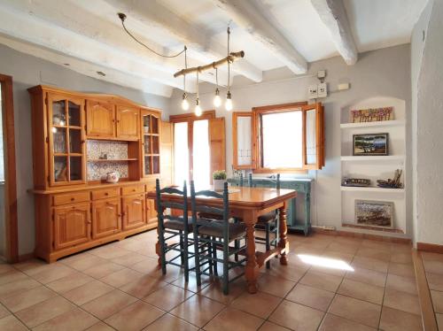 eine Küche mit einem Holztisch und Stühlen in der Unterkunft Casa Escola in Pobla de Segur