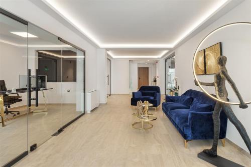 Cens Silver Luxury Suites في يوانينا: غرفة معيشة مع كراسي زرقاء ومرآة