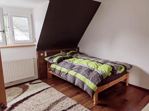 a bedroom with a bed with a black and green comforter at Ferienhaus Emi 
