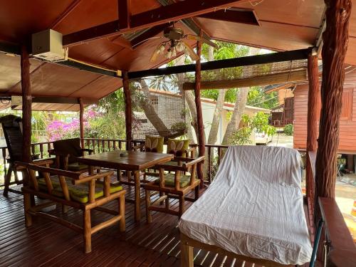 a wooden porch with a table and chairs on a deck at Bangpo Village in Ban Bang Po