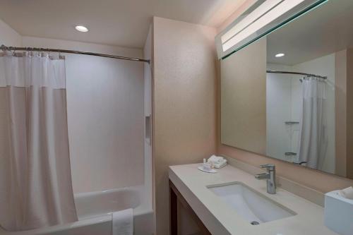 a bathroom with a sink and a shower and a mirror at Courtyard by Marriott Houston Sugar Land/Lake Pointe in Sugar Land