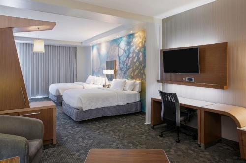 a hotel room with two beds and a desk at Courtyard by Marriott Hot Springs in Hot Springs