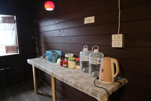 Una mesa con botellas de agua y un exprimidor. en บ้านน่านโฮมสเตย์, en Nan