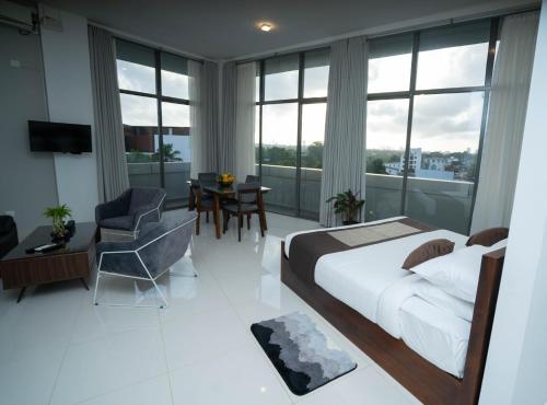 - une chambre avec un lit, une table et une chaise dans l'établissement Quest Colombo Residencies, à Talawatugoda