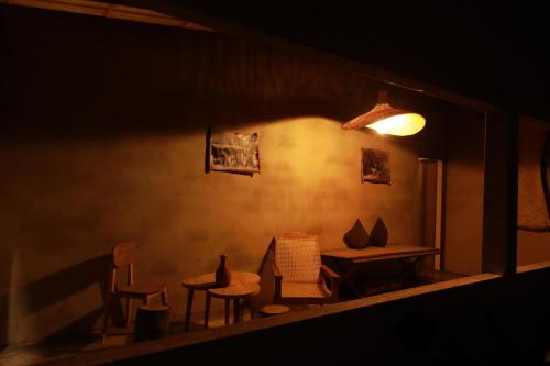 a room with chairs and a table and a lamp at Kirãmam Villa in Pasikuda