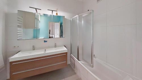 a bathroom with a sink and a shower and a mirror at nice and cosy apartment in Edegem