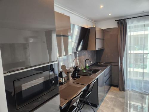 uma cozinha com electrodomésticos em aço inoxidável e preto em Seaview studio private parking included - Beach Residence em Mamaia Nord – Năvodari