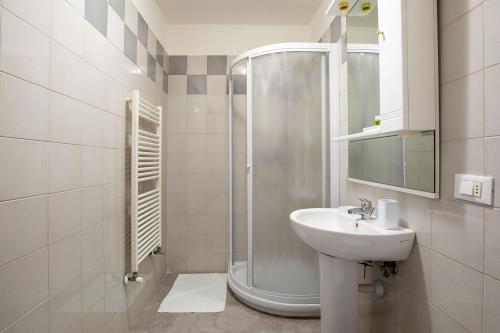 a white bathroom with a shower and a sink at Casa Adriana in Riomaggiore