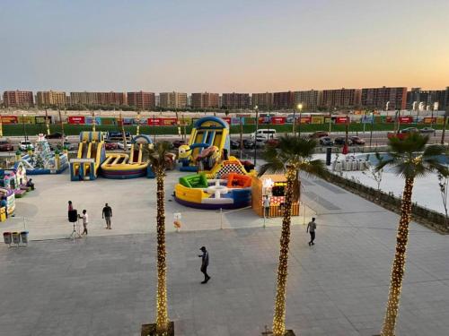 a park with a playground with palm trees and slides at Porto golf marina ,2 bedrooms , Families only in El Alamein