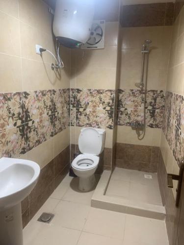 a bathroom with a toilet and a shower and a sink at Porto golf marina ,2 bedrooms , Families only in El Alamein