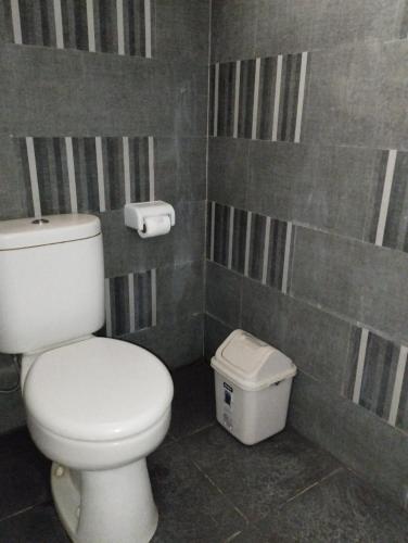 a bathroom with a toilet and a trash can at Sunset Pandawa Villa in Ubud