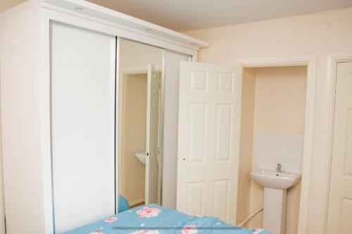 a bedroom with a mirror and a sink at Immaculate 3-Bed House in Dudley in Dudley