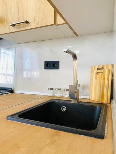 - un évier de cuisine avec un robinet dans l'établissement Апартаменты от BVO Group, à Almaty