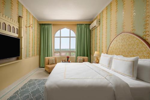 Cette chambre comprend un grand lit et une fenêtre. dans l'établissement Brij Gaj Kesri, Bikaner - A Boutique Luxury Palace, à Bikaner