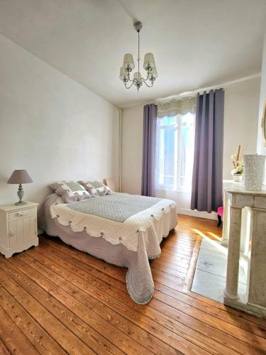 une chambre avec un lit et un parquet dans l'établissement Appartement douillet en hyper centre de Dieppe, à Dieppe