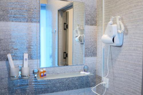 a bathroom with a shower with a mirror at Aperol Hotel in Tashkent