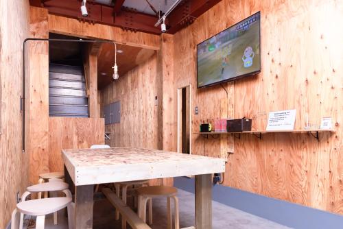 Una mesa con sillas y un televisor en una pared de madera. en Vacation"Ninja"house Secretbase near Asakusa, en Tokio