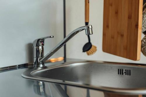 a kitchen sink with a spatula on a counter at Zoo apartment in Emmen