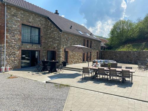 une terrasse avec une table et un parasol dans l'établissement le 701, à Theux