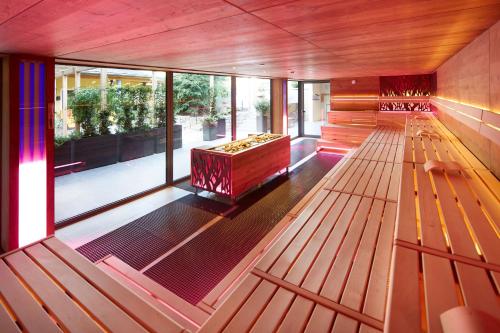 an empty room with wooden benches and large windows at Wellness & Naturresort Reischlhof in Wegscheid