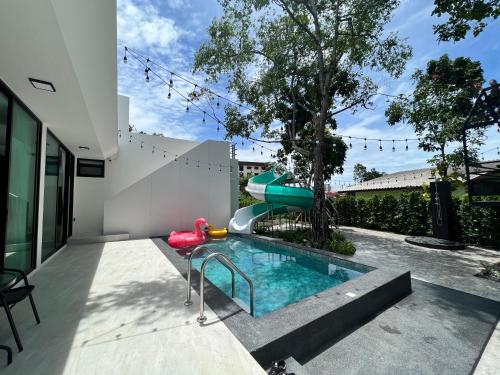 a swimming pool with a slide in a house at 168 Garden Pool Villa in Nong Prue