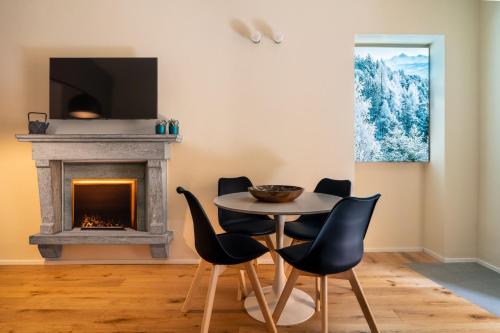 a dining room with a table and chairs and a fireplace at Aosta Holiday Apartments - Sant'Anselmo in Aosta