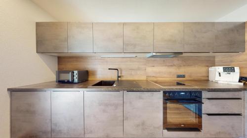 a kitchen with stainless steel cabinets and a stove top oven at PitzPlus Appartements in Sankt Leonhard im Pitztal