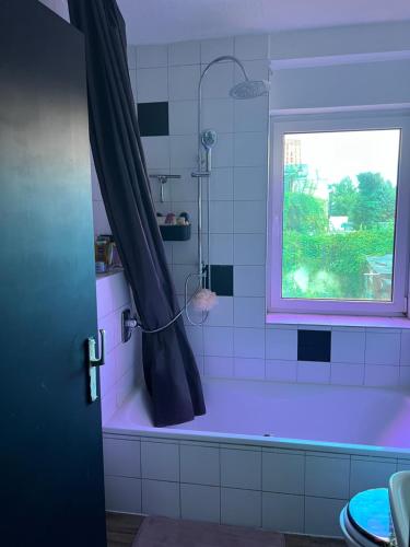 een badkamer met een paars bad en een raam bij Zimmer Nähe Darmstadt in Roßdorf