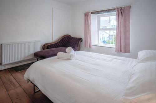 a white bed with a towel on it in a bedroom at Melbourne Cottage - 3 Bedroom Cottage - Pembroke in Pembroke