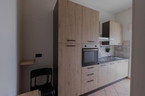 cocina con armarios de madera y microondas en Zara House Holiday Home, en Palmi