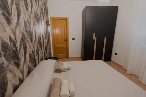 a bedroom with a white bed with slippers on it at Zara House Holiday Home in Palmi