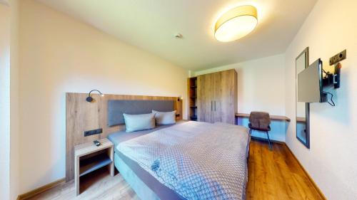 a bedroom with a bed and a table and a chair at PitzPlus Appartements in Sankt Leonhard im Pitztal