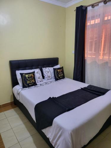 um quarto com uma cama grande com almofadas em G&G Homes WESTINDIES em Eldoret