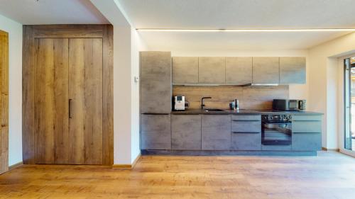 a kitchen with a wooden door in a room at PitzPlus Appartements in Sankt Leonhard im Pitztal