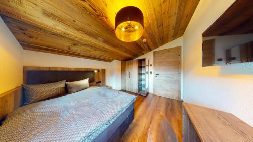 a bedroom with a bed and a wooden ceiling at PitzPlus Appartements in Sankt Leonhard im Pitztal