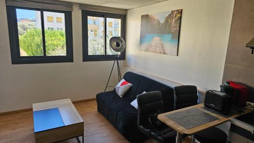 un salon avec un canapé et une table dans l'établissement Grand studio climatisé, à La Ciotat