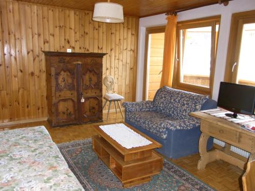 a living room with a blue couch and a table at Casa Elisa in Pozza di Fassa