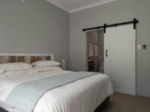 クラレンスにある6 Sleeper Villa Clarens Golf Estateの白いベッドルーム(大型ベッド1台、スライドドア付)