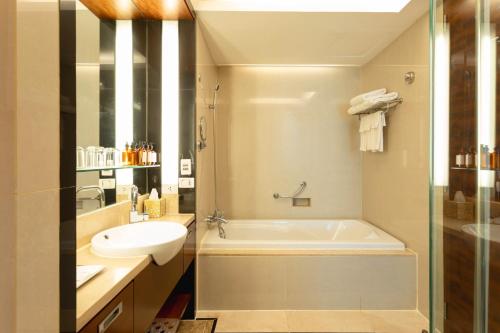 y baño con bañera blanca y lavamanos. en AETAS lumpini, en Bangkok