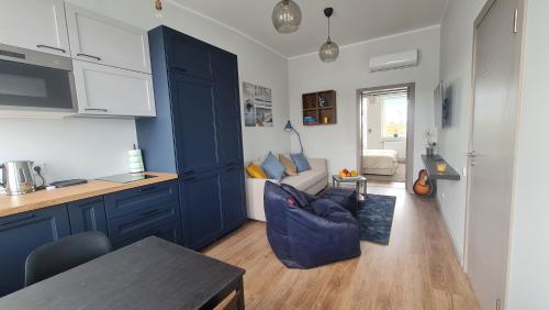 una cocina con armarios azules y un sofá azul en una habitación en Float House Nr 659 en Riga