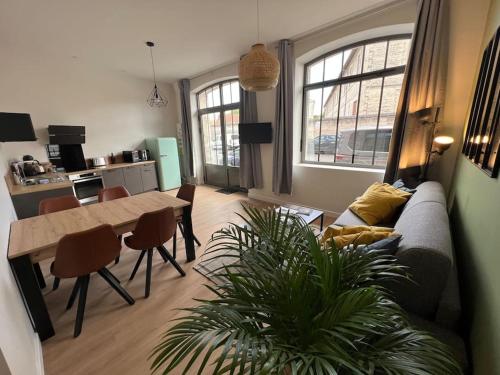 a living room with a couch and a table at Appartement centre-ville * RDC * clim * WIFI * Haut de gamme * in Angoulême