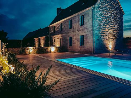 a swimming pool in front of a house at night at Domaine du Mimosa in Perros-Guirec