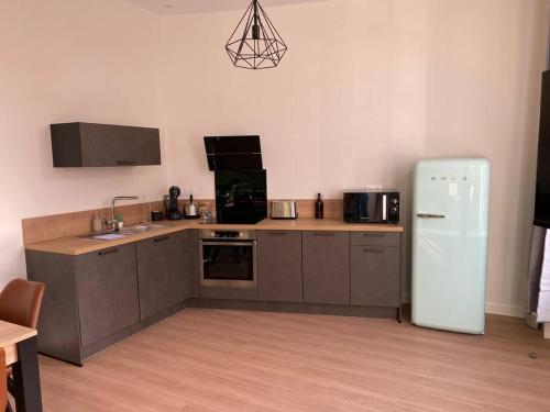 a kitchen with a white refrigerator in a room at Appartement centre-ville * RDC * clim * WIFI * Haut de gamme * in Angoulême