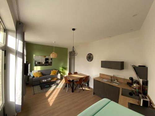a living room with a couch and a table at Appartement centre-ville * RDC * clim * WIFI * Haut de gamme * in Angoulême