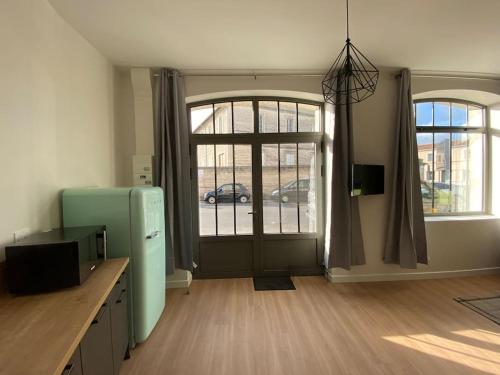 a room with a refrigerator and a door with a window at Appartement centre-ville * RDC * clim * WIFI * Haut de gamme * in Angoulême